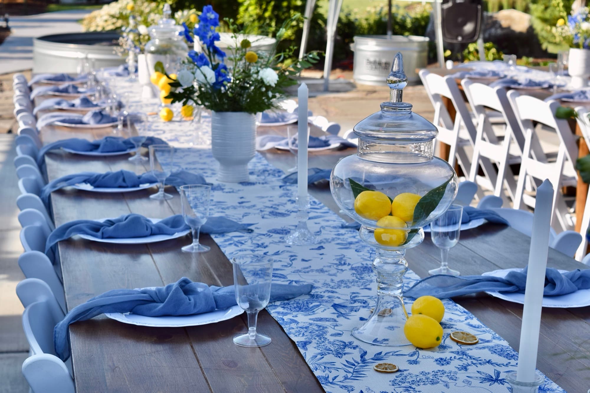 A wide styled wedding tablescape with layered florals and place settings.